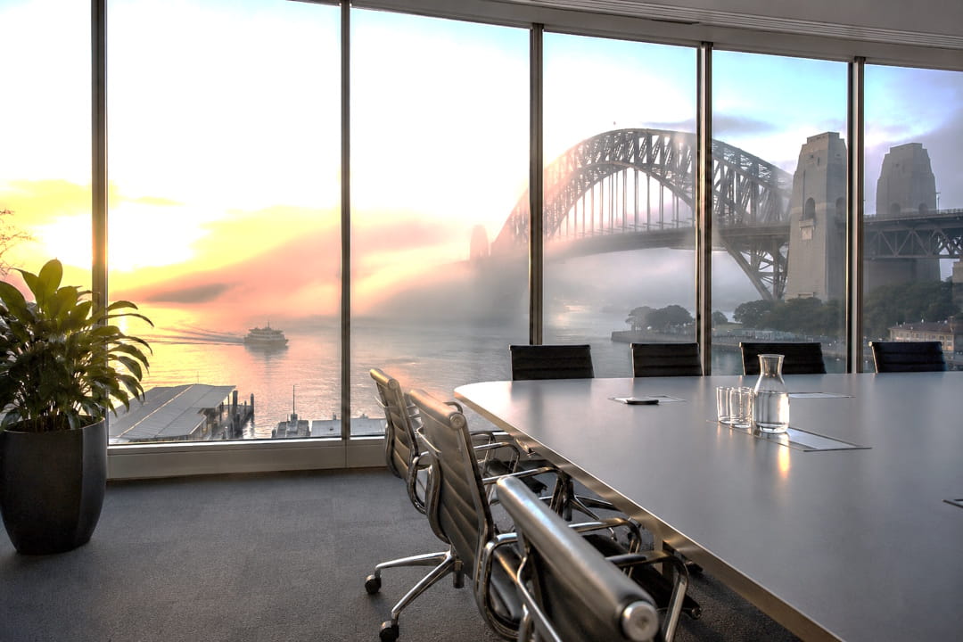 Modern Sydney boardroom overlooking Sydney Harbour Bridge disappearing into morning fog, representing CRM strategy, governance, operational clarity, Microsoft Dynamics 365 advisory, and long-term business visibility.