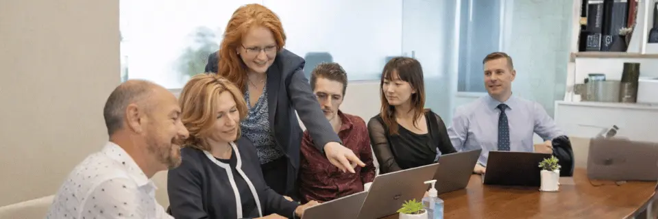 Business coaching session with mentor guiding team in meeting room